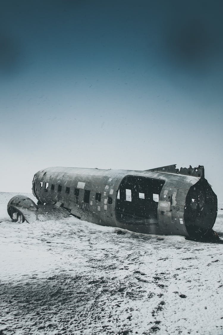 Ruined Airplane Cabin On Snowy Land Under Sky