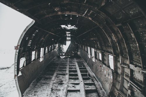Aged rusty aircraft interior on snowy terrain after disaster