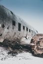 Ruined plane with demolished engine after accident on snowy terrain under sky in wintertime