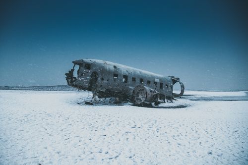 Free Old abandoned airplane after disaster on snowy terrain behind mounts under sky in winter Stock Photo