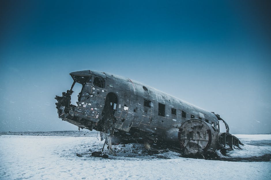 Crashed airplane cabin after accident on snowy land under sky in winter
