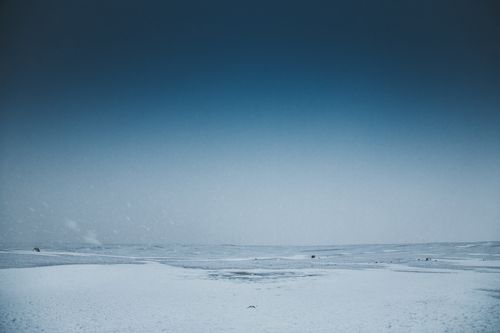 Free Endless sea with splattering water and horizon line near snowy coast under sky in wintertime Stock Photo