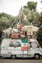 Shabby van decorated with multiple Italian flags and garlands
