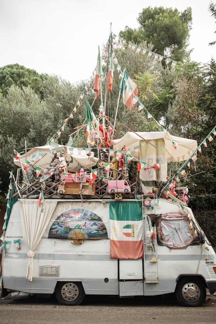 Shabby Van Decorated With Multiple Italian Flags And Garlands