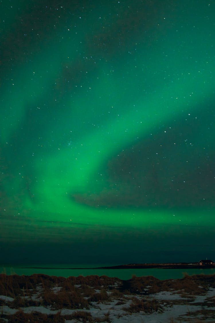 Sea And Rough Shore Under Northern Lights In Winter