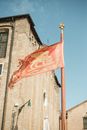 Waving flag of Venice against historical building