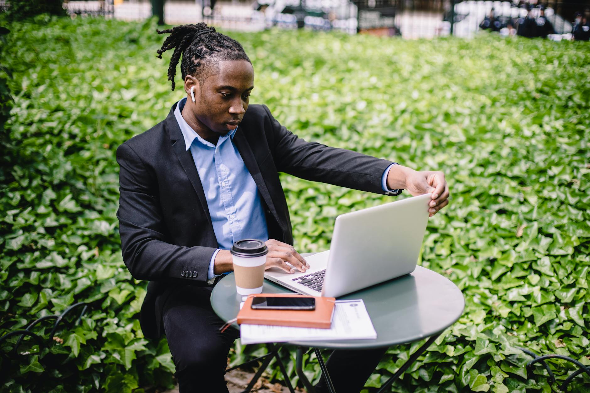 Concentrated ethnic businessman using laptop in park