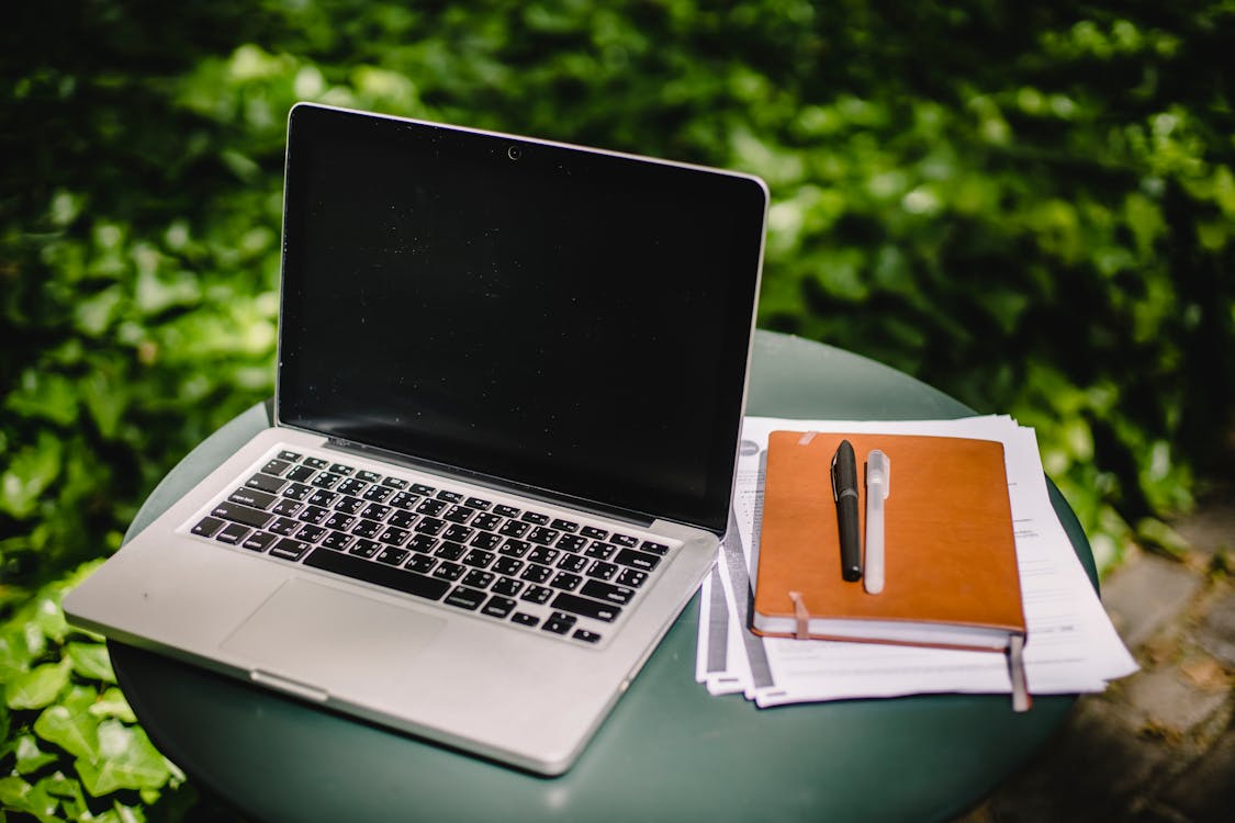 Free Laptop and diary on table in garden Stock Photo