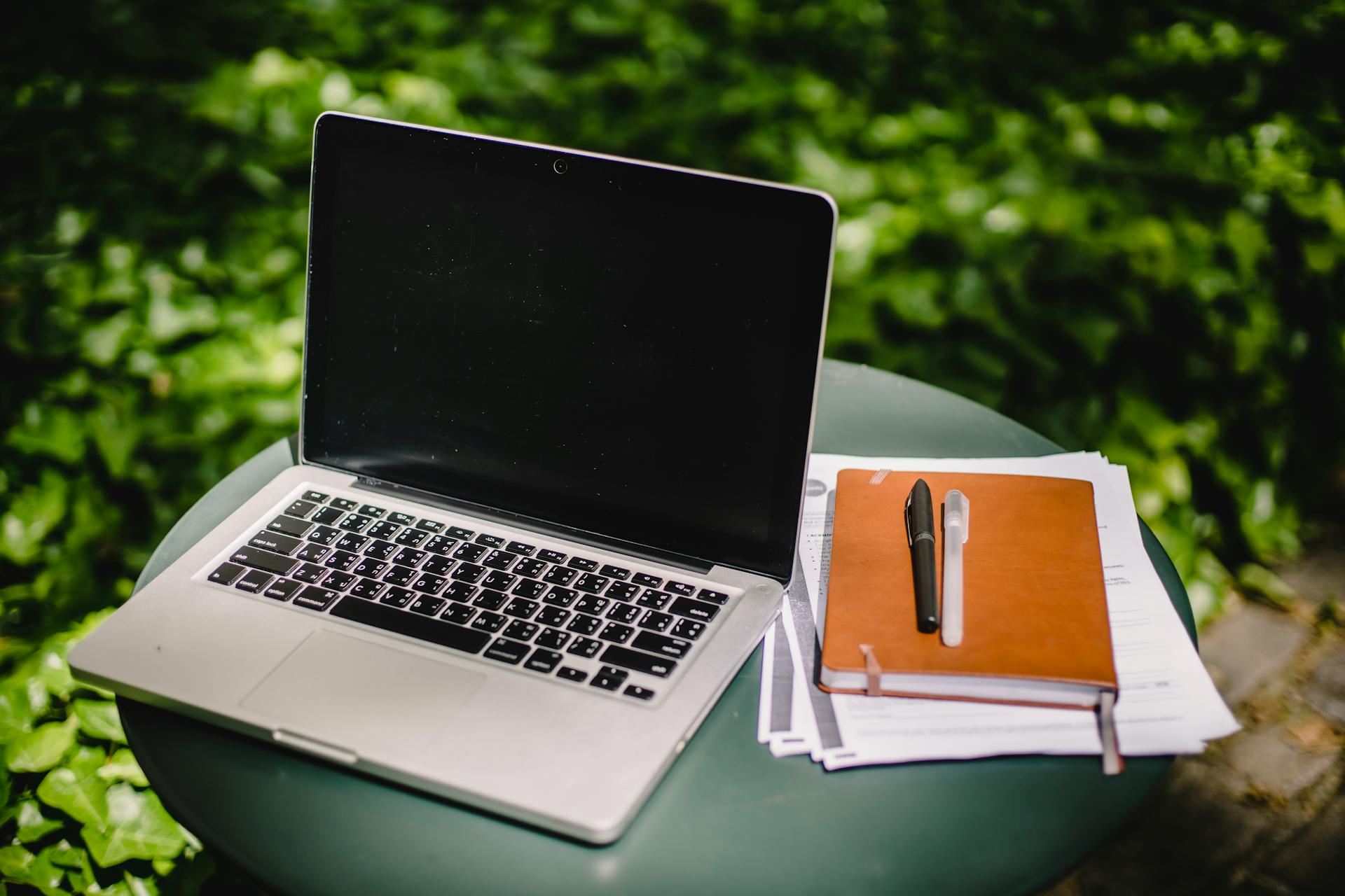 Laptop and diary on table in garden