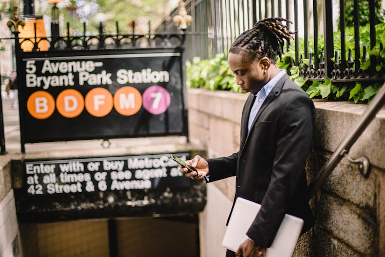 Young African American Office Worker Using Smartphone On Street