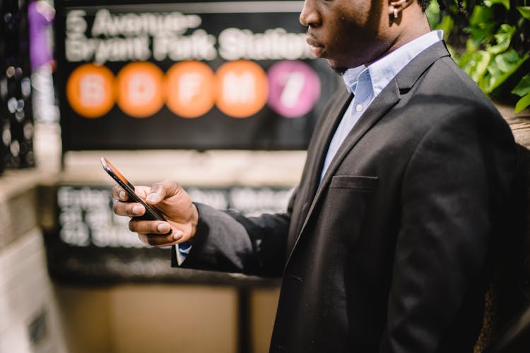 African American Office Employee Using Cellhone On Street