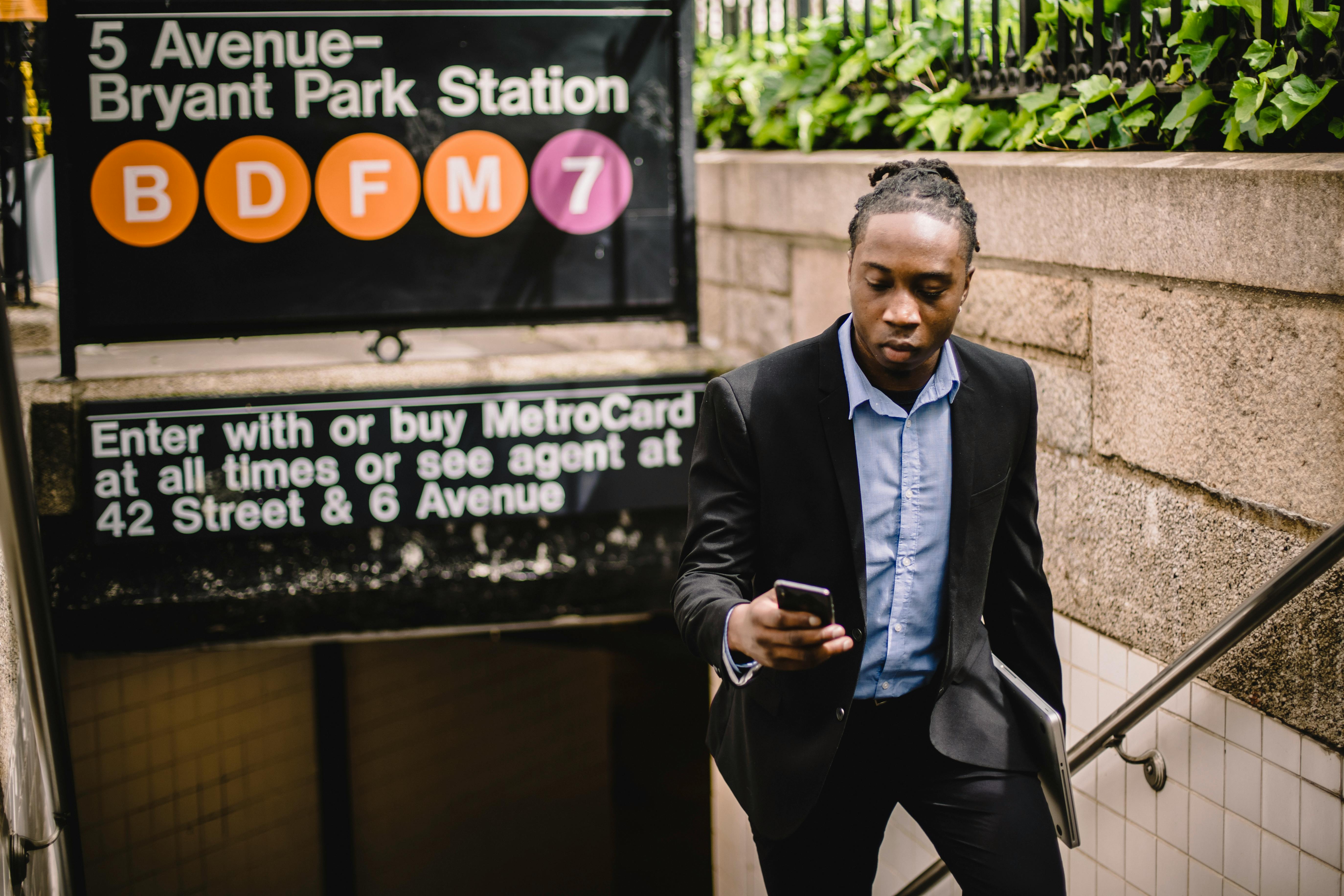 young black male in office suit using cellphone on street