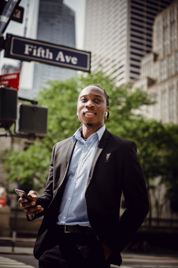 Cheerful Black Male Manager With Smartphone On Fifth Avenue In New York