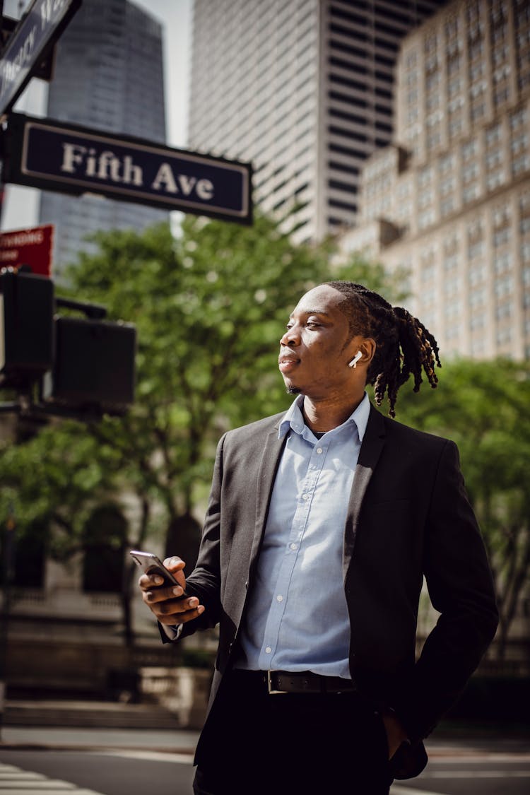 Young African American Office Worker Listening To Music On Mobile