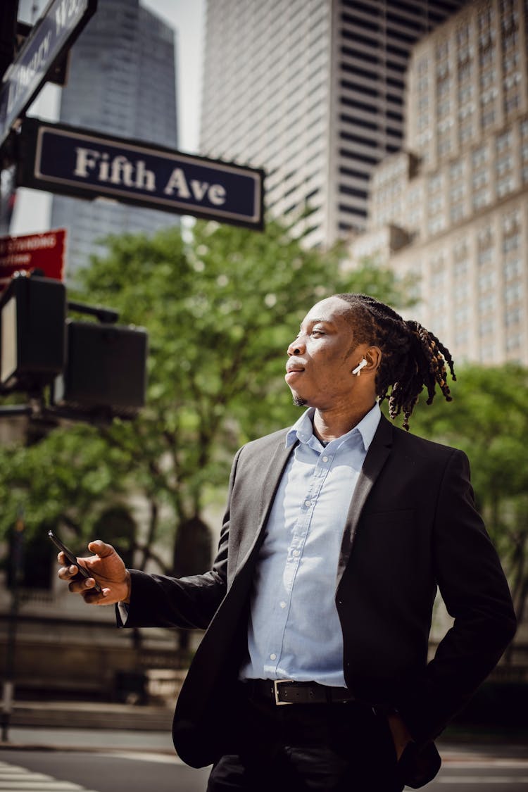 Young Male In Office Suit Listening To Music On Cellphone