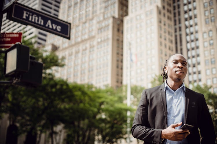 Young Office Employee Listening To Music On Manhattan Street