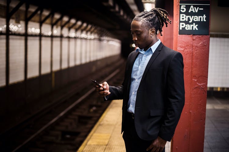 Serious Male Messaging On Phone While Waiting For Subway Train