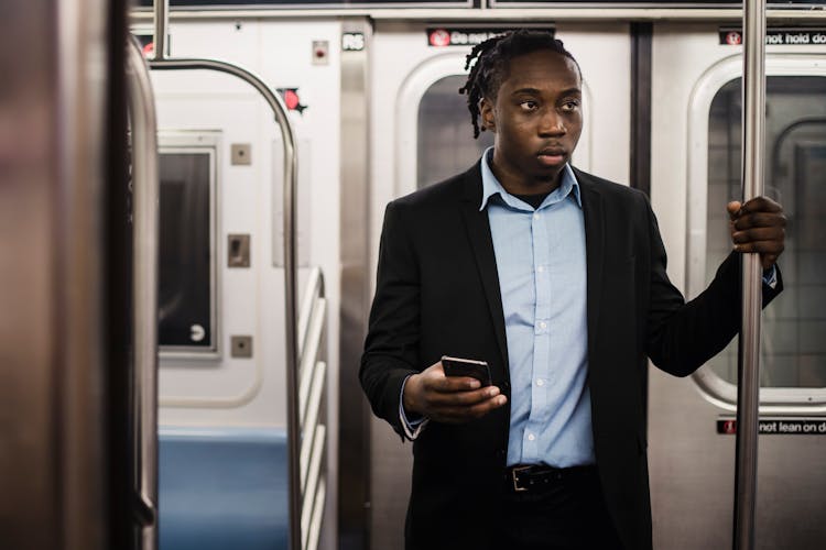 Young Black Man In Suit Getting To Work By Subway