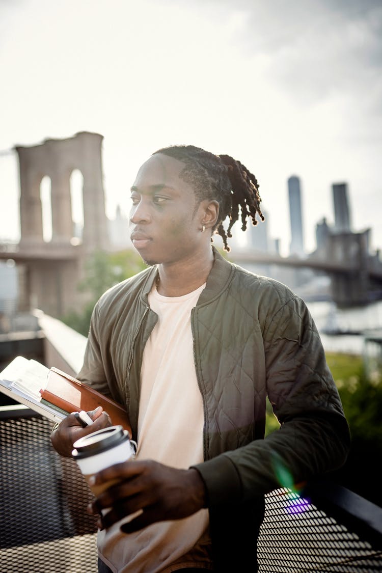 Young Black Student With Cup Of Coffee And University Books