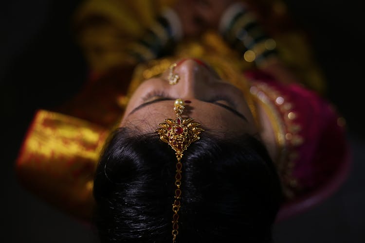 Woman Wearing A Gold Head Necklace