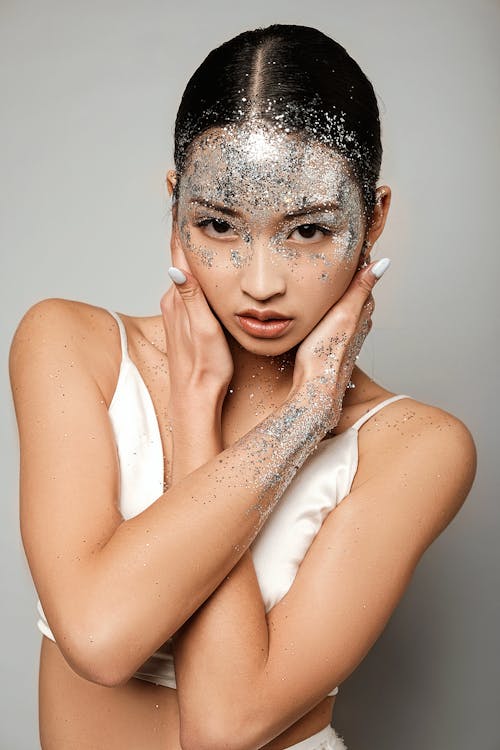 Stylish Asian woman with craft glitter on forehead