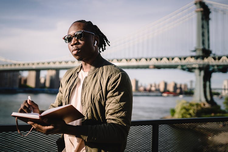 Focused Black Man Searching Location Standing On River Embankment