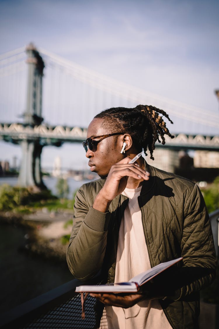 Focused Black Man Waiting For Meeting On River Embankment