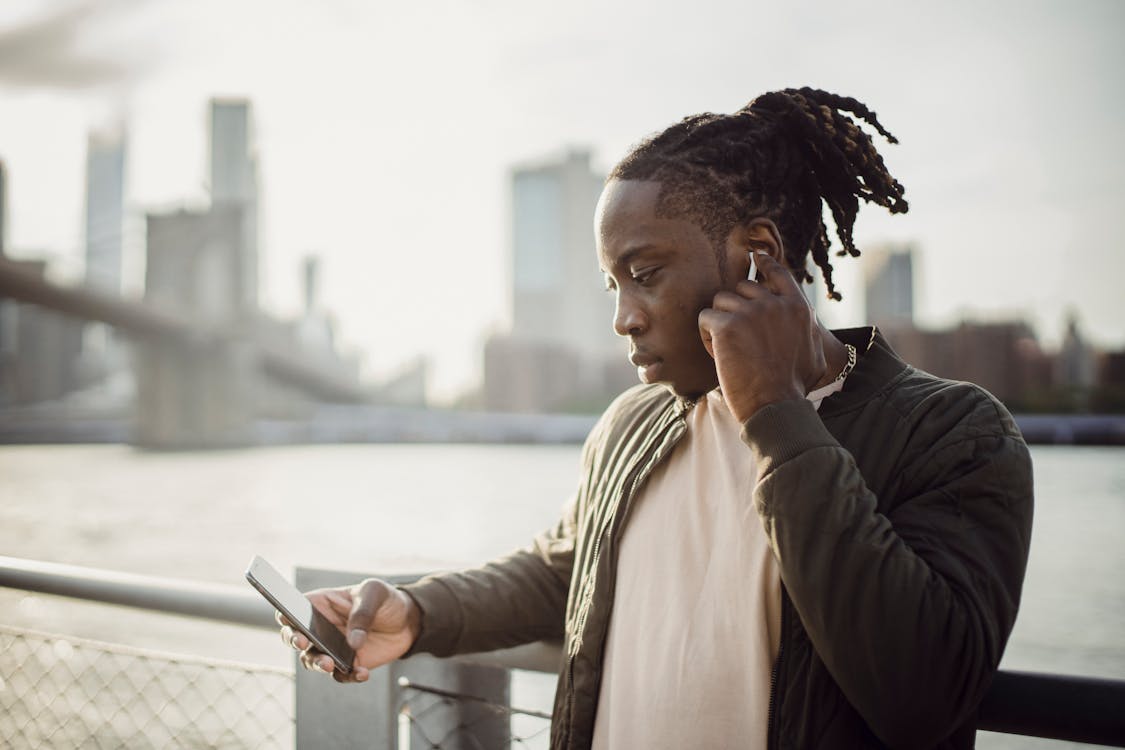 A man with dreadlocks talking on a cell phone photo – Free Pearl