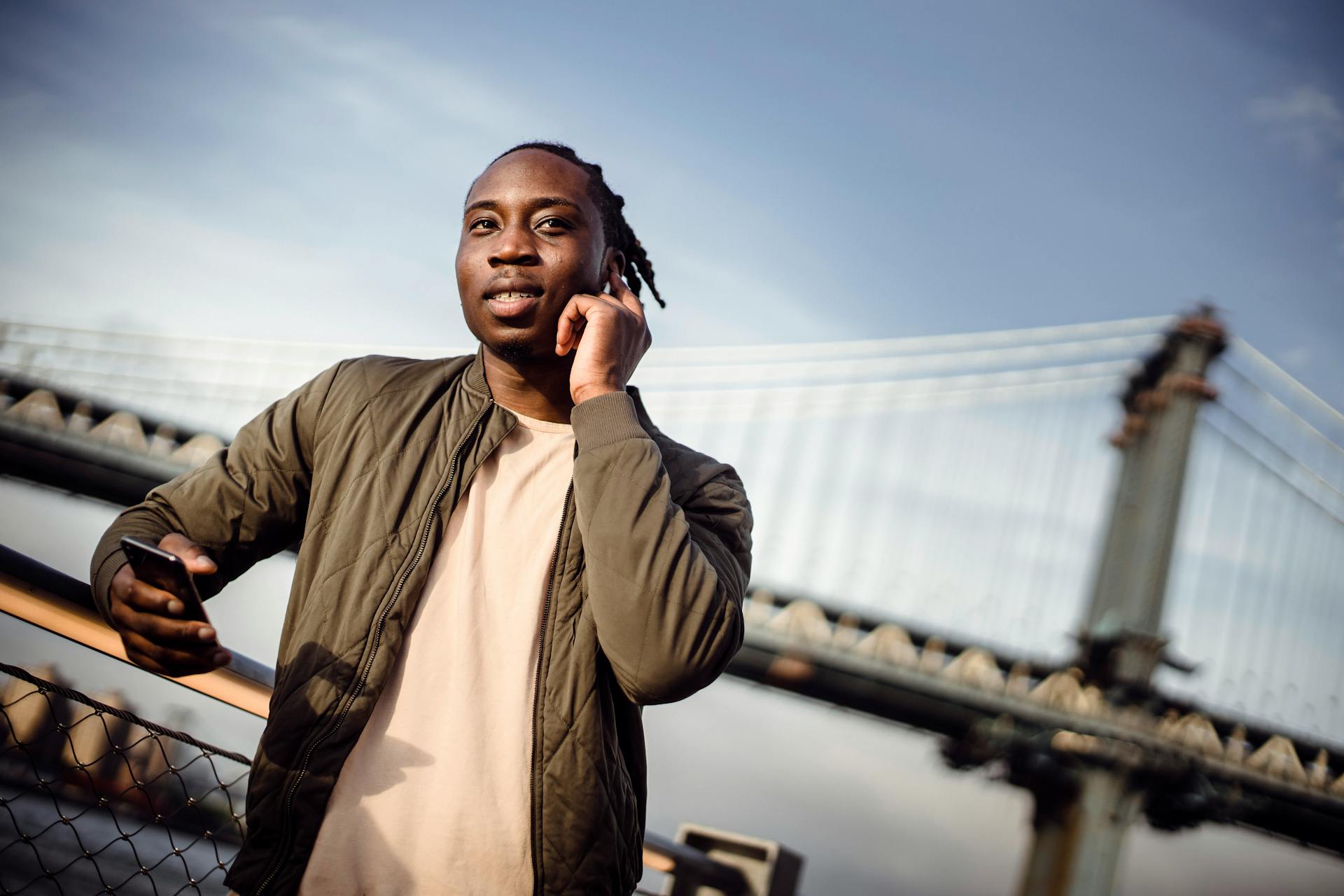 African American man calling on smartphone through earphones