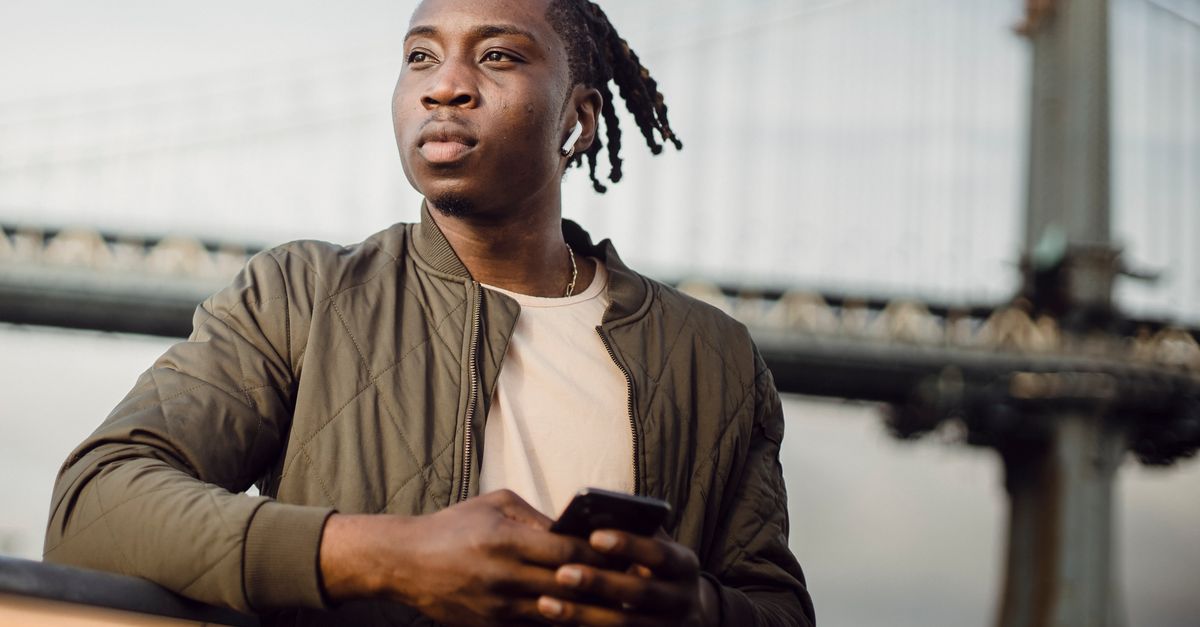person reading news on phone with thoughtful expression urban setting