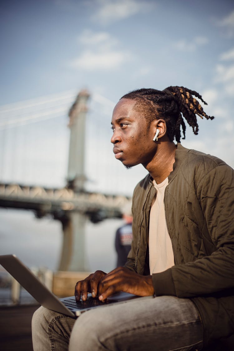 Focused Black Male Worker Typing On Laptop