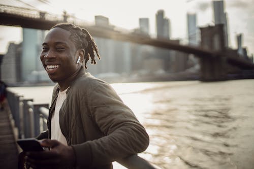 Cheerful black man spending day outdoors on quay