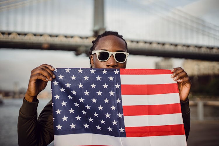 Young African American Male With American Flag Bandana Against Bridge