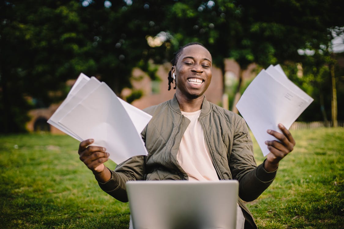 Student with documents and laptop happy about getting into university