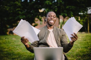 Free Student with documents and laptop happy about getting into university Stock Photo