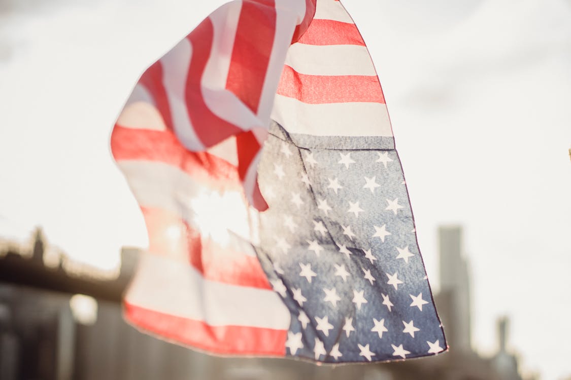 American flag kerchief waving in wind against blurred modern city