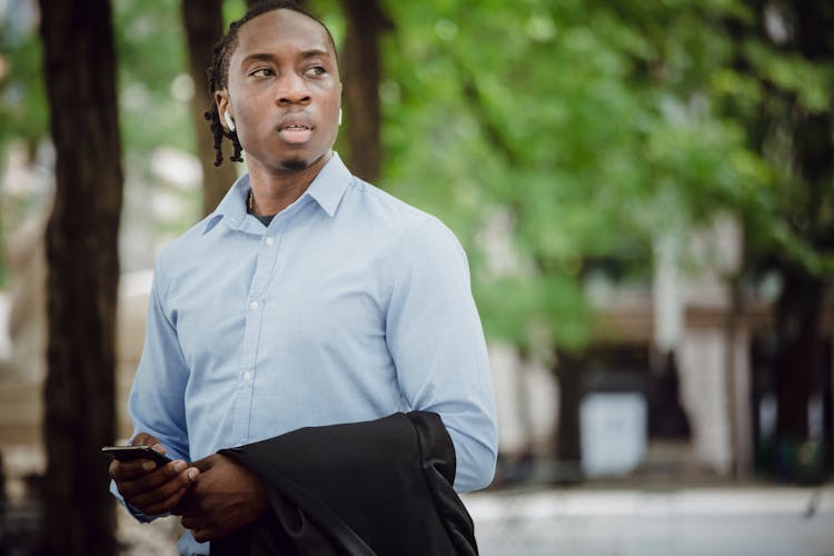 Confident Ethnic Office Worker With Smartphone In Park