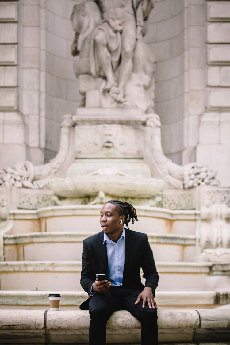 Elegant Black Male Manager With Smartphone Having Coffee Break On Stairs