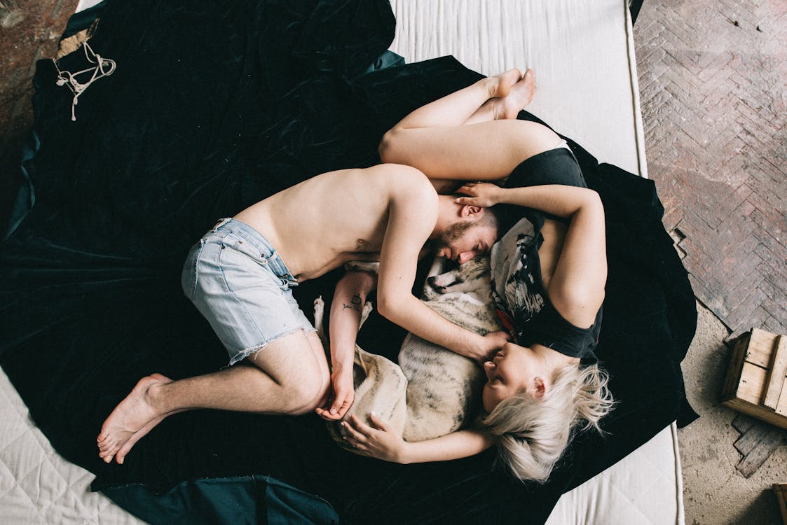 Couple Sleeping With Pet Dog