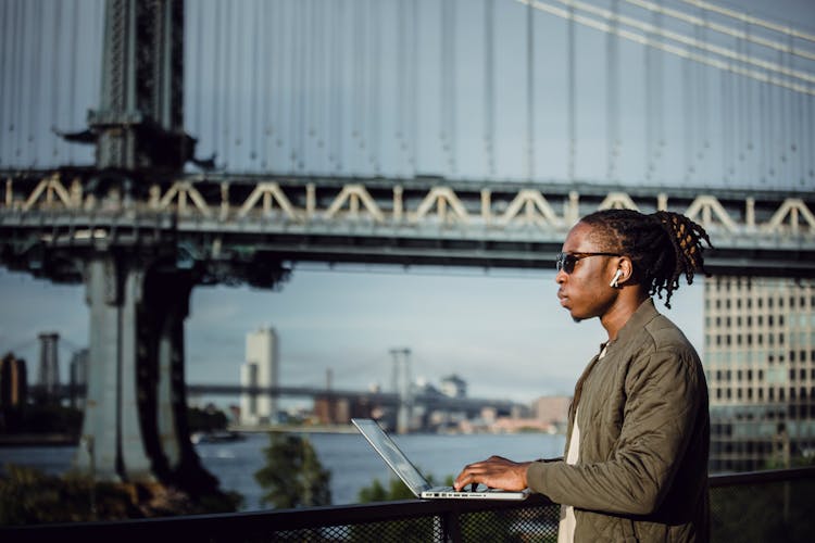 Young Black Man Working On Laptop And Listening To Music