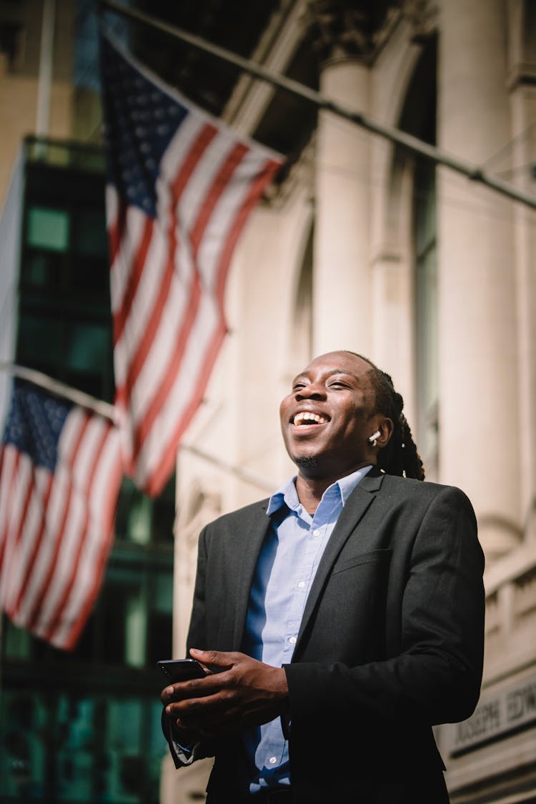 Back Man In Formal Suit With Cellphone Laughing On Street