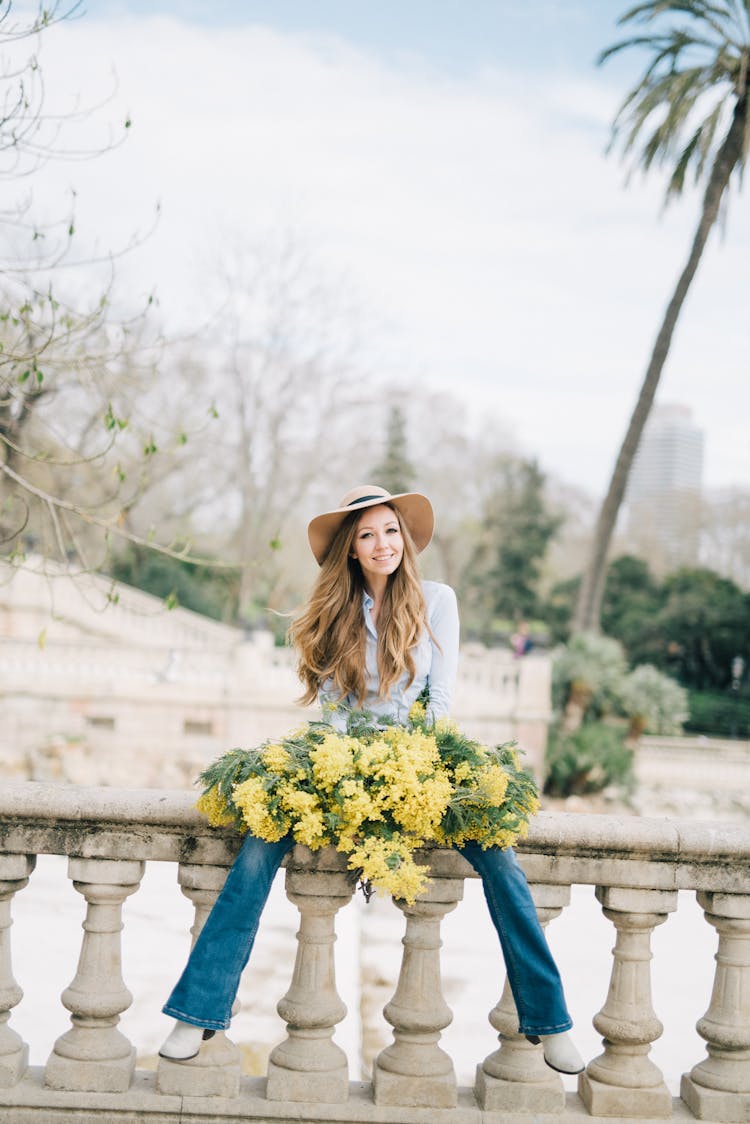 Woman In White Long Sleeve Shirt Holding Yellow And White Flower Bouquet