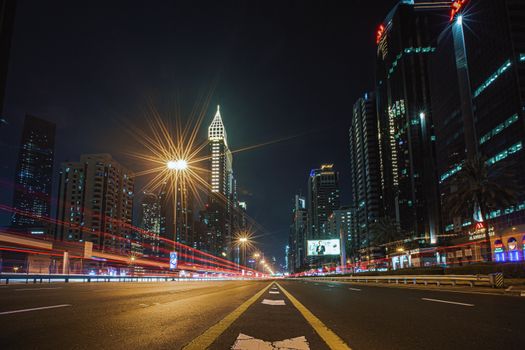 Captivating view of Dubai's illuminated skyline at night, showcasing modern architecture and dynamic light trails.