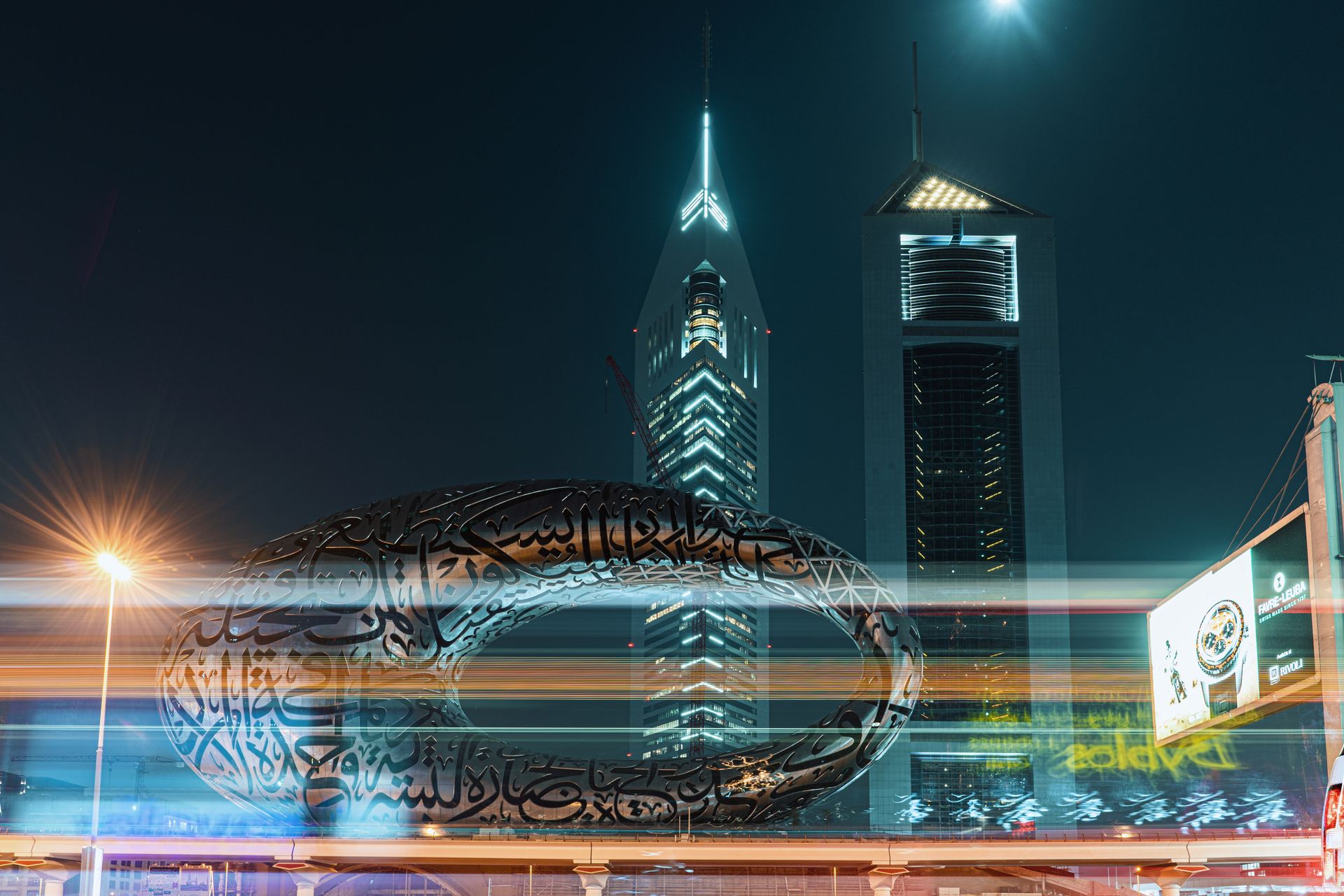 Stunning night view of Dubai's Museum of the Future, illuminated amidst skyscrapers.