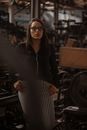 Woman in Black Jacket and Black and White Striped Pants Wearing Black Framed Eyeglasses