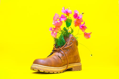 Modern style leather boot with ribbed sole and cords decorated with bright flowers