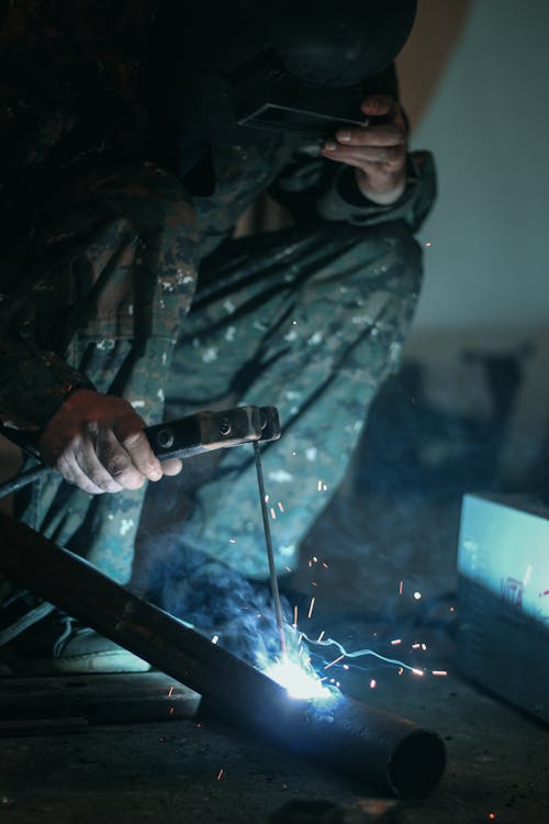 Free A Person Welding Iron Bars Together Stock Photo