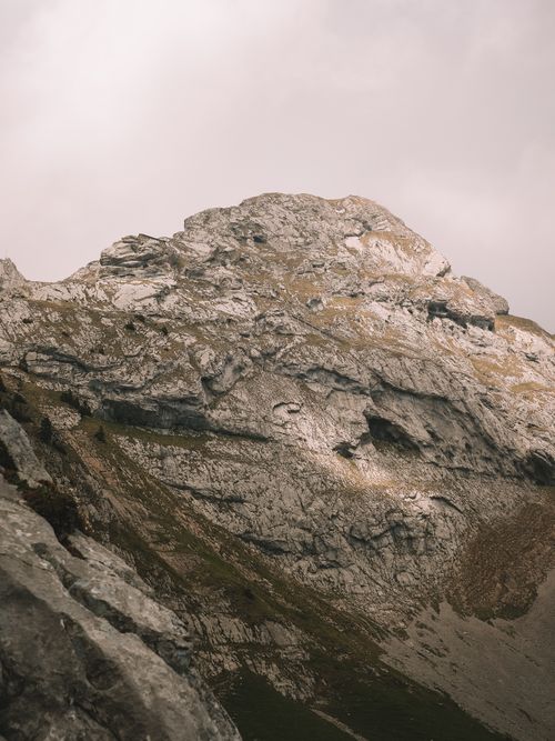 Free Explore the rugged beauty of a majestic rocky mountain under a cloudy sky, capturing nature's raw essence. Stock Photo