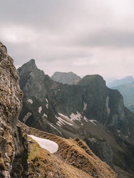Breathtaking view of rocky mountain peaks under a cloudy sky, showcasing natural beauty.