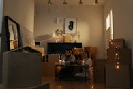 一对夫妇搬家时，在一个装满盒子的房间里，周围点着蜡烛，灯光温馨舒适